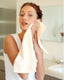 Woman in a kitchen using a towel to dry off