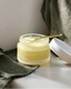 Jar of 'Promise' radiance balm on a neutral background