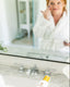 Person applying skincare product in front of a mirror