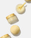 Skincare jars with gold lids on a white background